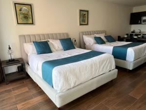 two beds with blue and white sheets in a bedroom at Bellísima Suite, 2 Camas Queen, Gym, en Interlomas in Mexico City