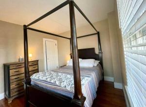 a bedroom with a canopy bed and a dresser at THE HANNAH HOUSE - DOWNTOWN HISTORIC LANCASTER in Lancaster