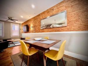 ein Esszimmer mit einem Holztisch und gelben Stühlen in der Unterkunft THE STAGE HOUSE - CITY CENTER THEATER DISTRICT in Lancaster