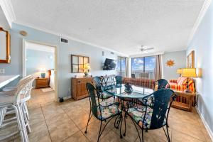 une salle à manger avec une table et des chaises en verre dans l'établissement Romar Place 705 by Vacation Homes Collection, à Romar Beach