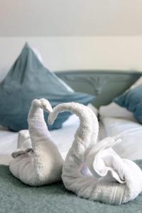 two towel swans sitting on top of a bed at Landgasthaus Zum Engel in Neuleiningen