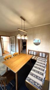 Un comedor con mesa y sillas de madera. en Becci Apartment-Free Parking, en Kapfenberg