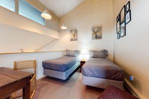 スティームボート・スプリングズにあるSki Time Square 516のベッド2台とテーブルと窓のある寝室