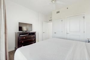 Un dormitorio blanco con una cama y un televisor de pantalla plana. en Luau 6909, en Destin 27 fotos más
