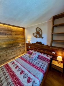 a bedroom with a bed with a wooden wall at Nido Alpino - Vista Montagne, Ski e Relax Terme a 150m in Pré-Saint-Didier