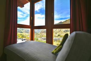 a bedroom with a large window looking out at a mountain at A 2 min de Grandvalira I Ski, Vistas, Wifi y Parking I Aliga in Soldeu +19 photos