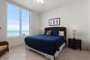 a bedroom with a bed and a large window at Prestigious Luxury Beach & Bay Patios XL Size in South Padre Island