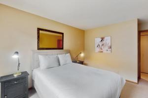 a bedroom with a white bed and a mirror at Simba Run 2305 in Vail +15 photos