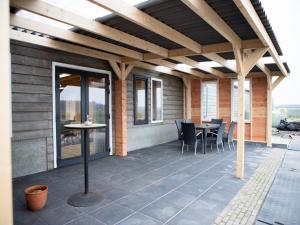un patio avec une pergola en bois avec une table et des chaises dans l'établissement Spacious holiday home in Oirschot near forest, à Haghorst