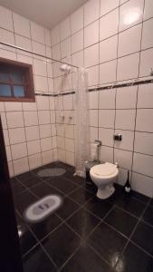 a white bathroom with a toilet and a shower at Santos & Oliveira in Diamantina