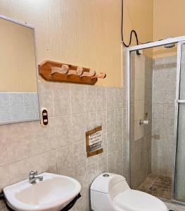 a bathroom with a toilet and a sink and a shower at Hotel Hernandez in Chiquimula