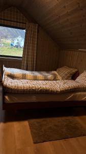 a couple of beds in a room with a window at Steineveien 300 in Vestvågøya