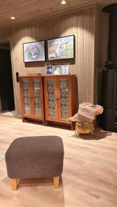 a room with a television and a ottoman in a room at Steineveien 300 in Vestvågøya