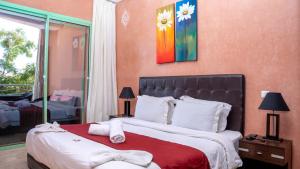 een slaapkamer met een groot bed met een rode deken bij Appartements Marrakech Garden in Marrakesh +28 foto's