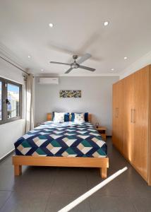 a bedroom with a bed and a ceiling fan at Villa Paradis à 100m de la plage in Flic-en-Flac