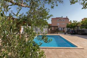 a swimming pool in front of a house at Mobile home RIA in Privlaka