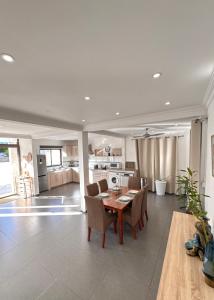a kitchen and dining room with a table and chairs at Villa Paradis à 100m de la plage in Flic-en-Flac