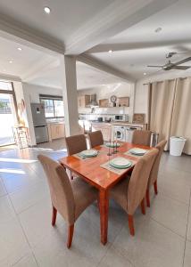 a kitchen and dining room with a wooden table and chairs at Villa Paradis à 100m de la plage in Flic-en-Flac