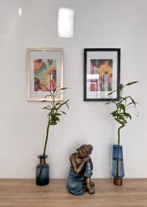 two plants in vases and a statue on a table at Villa Paradis à 100m de la plage in Flic-en-Flac