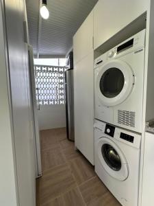 eine Waschküche mit Waschmaschine und Trockner in der Unterkunft Guesthouse Cervantes - Rooms cerca del centro de Granada in Granada