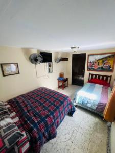 a bedroom with a bed and a tv on the wall at Hotel Casa Morazán in Granada