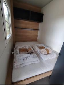 two twin beds in a small room with a window at Mobile home RIA in Privlaka