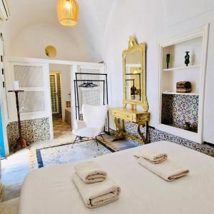 a bedroom with a bed and a mirror and a chair at Dar Mima rooftop sea view in Sidi Bou Saïd