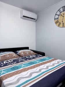 a bedroom with a bed with a clock on the wall at Smylie home in Fort-de-France
