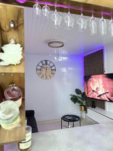 a room with a clock on the wall and a table at Smylie home in Fort-de-France