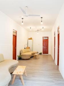 a living room with a couch and a table at Shadow Isles Himandhoo in Himandhoo 