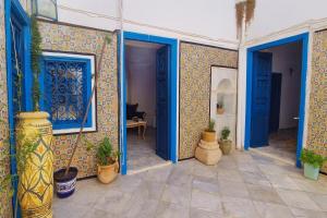 a room with blue doors and potted plants at Dar Mima rooftop sea view in Sidi Bou Saïd +10 photos