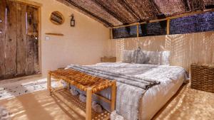 a bedroom with a bed and a wooden ceiling at Berber Beldi Camp in Imsouane