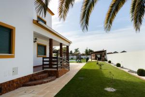 a house with a green lawn in front of it at Quinta das Laranjeiras in Marinhais