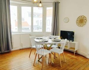 a dining room with a white table and chairs at REPOS 150m plage Coeur de Berck in Berck-Plage