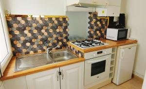 a small kitchen with a stove and a sink at REPOS 150m plage Coeur de Berck in Berck-Plage