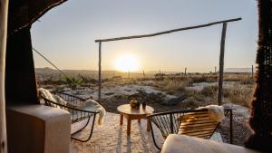 依索安Berber Beldi Camp的露台上的桌椅享有日落美景