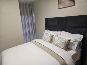 a bedroom with a bed with white sheets and pillows at Eland Ridge in Boksburg +15 photos