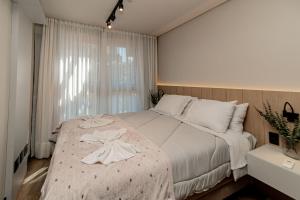 a bedroom with a large bed with a dress on it at Ap com piscina, ótima localização in Canela +22 photos