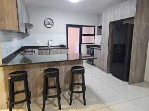 a kitchen with a counter and two bar stools at Eland Ridge in Boksburg