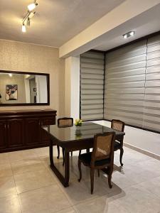 ein Esszimmer mit Tisch und Stühlen und einem Spiegel in der Unterkunft #3 Departamento de 2 habitaciones en el centro de Tarija! in Tarija