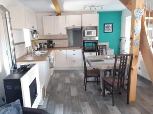 a kitchen with a table and chairs in a room at Domaine au Grès des Pierres in Flexbourg +14 photos