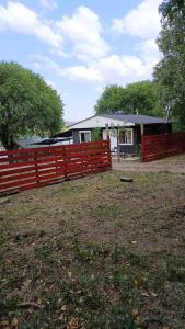 a red fence in front of a house at cabañas Saona in Molinari