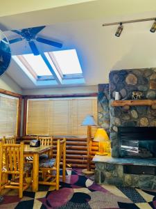 a living room with a table and a stone fireplace at Sandpoint Inn in Ponderay