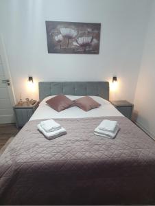 a bedroom with a large bed with two towels on it at Apartament central Blaj in Blaj