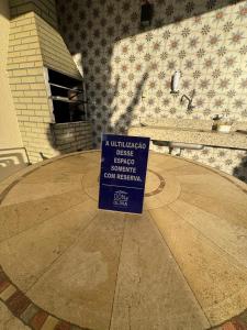 a sign sitting in the middle of a patio at Casa Arruda Climatizada 5 proximo shopping boulevard in Vitória da Conquista