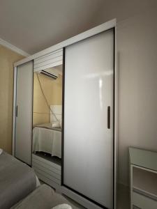 a sliding glass door in a bedroom with a bed at Casa Arruda Climatizada 5 proximo shopping boulevard in Vitória da Conquista