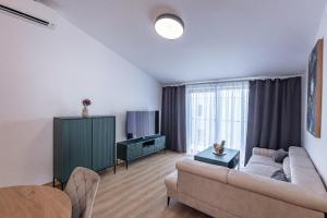 a living room with a couch and a tv at Villa Cherry in Rogoznica
