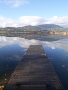 a dock on a body of water with mountains in the background at Waitts Loft over the Lake in Valley