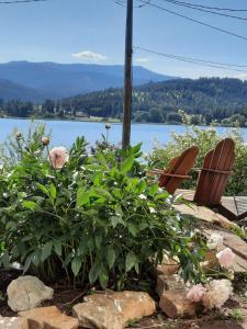 a couple of benches and flowers with a view of a lake at Waitts Loft over the Lake in Valley