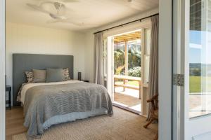 a bedroom with a bed and a sliding glass door at Escarpment House - Grand Hinterland Estate with Sweeping Ocean Views in Knockrow +36 photos